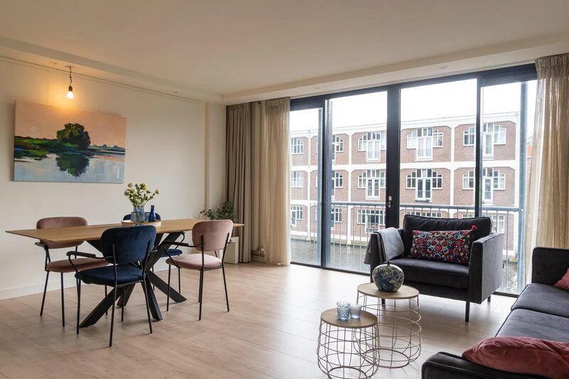 Lichte woonkamer met eethoek en grote raampartij in het project Donker Curtiusstraat in Amsterdam